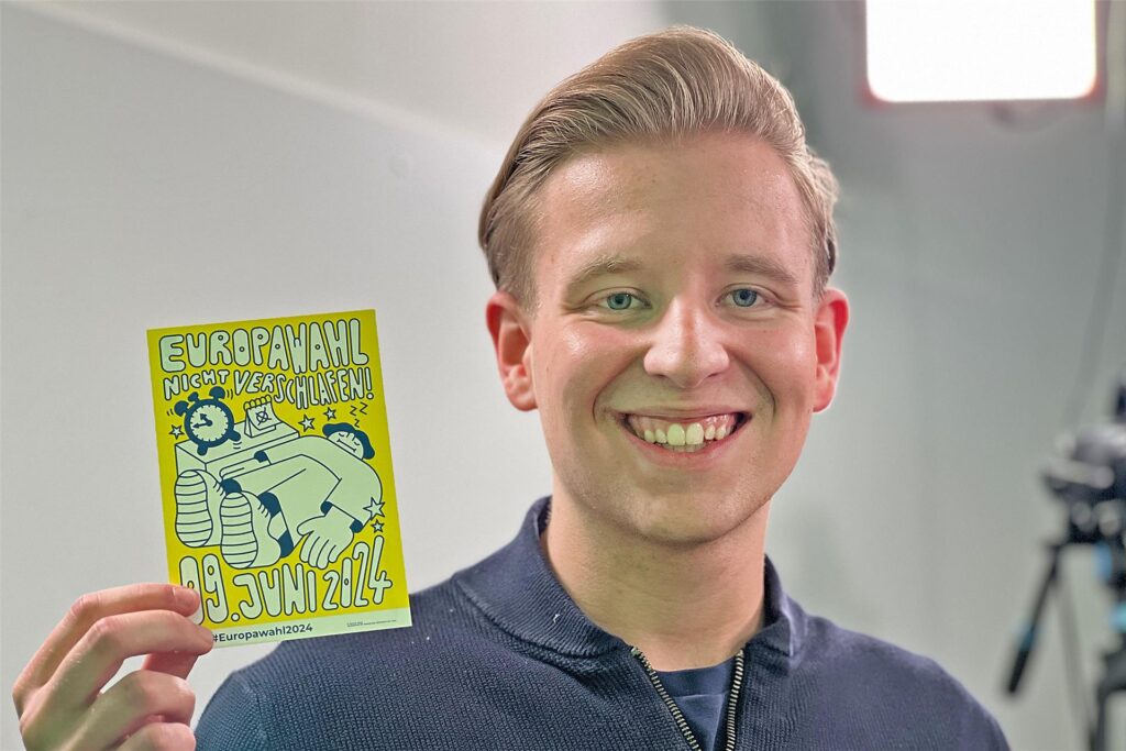 JU-Kreisvorsitzender Tim Stohlmann (21) hält einen Werbeflyer zur Europawahl in die Luft