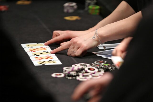 Ein Tisch, auf dem Karten gespielt werden. Daneben liegen Casino-Chips.
