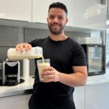 Ein Mann schüttet einen Eiweißdrink aus einem Shaker in ein Glas.
