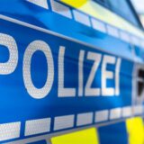 An der Tür von einem Streifenwagen steht der Schriftzug „Polizei“.