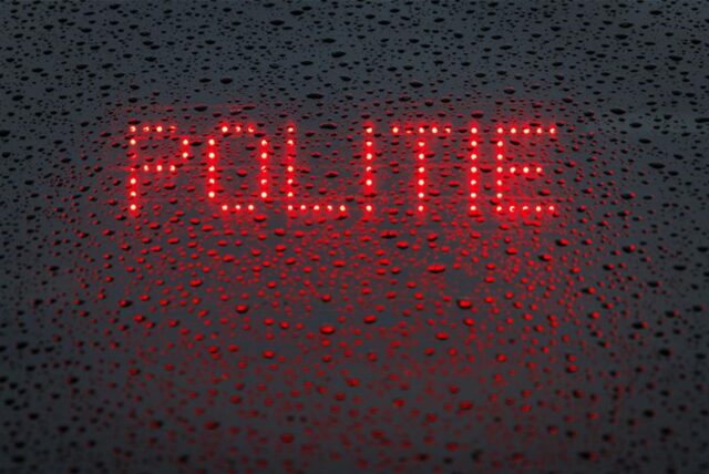 Das niederländische Wort „Politie“ („Polizei“) wird in der Heckscheibe von einem Einsatzfahrzeug angezeigt.