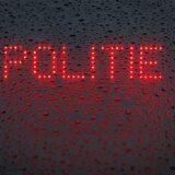 Das niederländische Wort „Politie“ („Polizei“) wird in der Heckscheibe von einem Einsatzfahrzeug angezeigt.