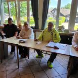 Ein Mann gibt in Fröndenberg seine Stimme bei der europawahl 2024 ab. Vier Wahlhelfer sitzen hinter Tischen.