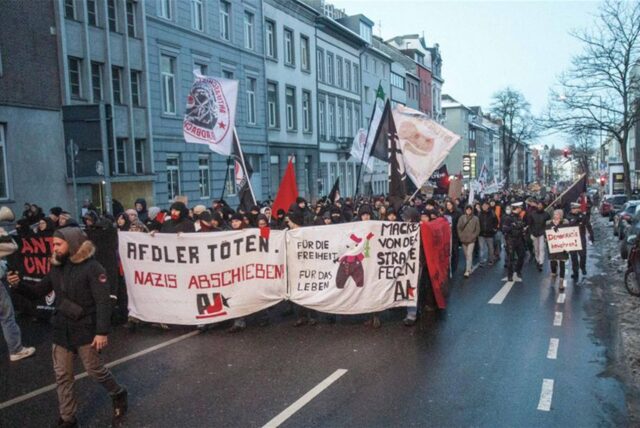 Teilnehmer einer Demonstration mit einem Plakat und der Aufschrift «AfDler töten. Nazis abschieben!».