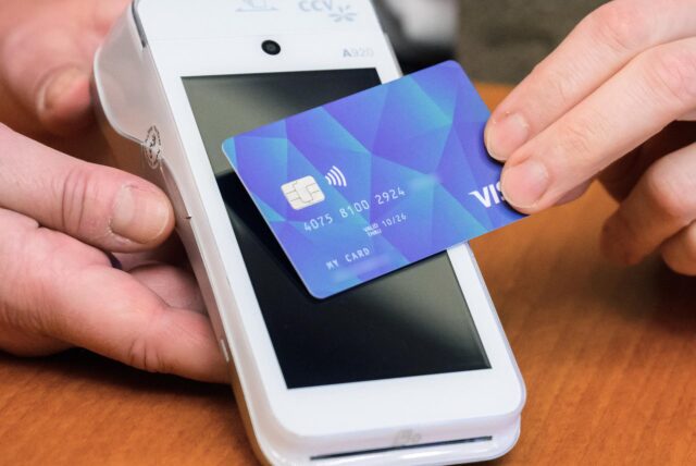 Mit einer Bankkarte wird über ein Kartenlesegerät bezahlt.