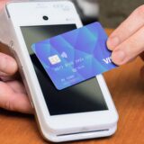 Mit einer Bankkarte wird über ein Kartenlesegerät bezahlt.