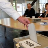 Ein Mann schmeißt seinen Stimmzettel in die Urne eines Wahllokals im Kreis Unna.