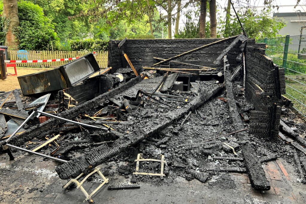 Auf dem Gelände der Kindertagesstätte Unterm Regenbogen in Unna-Königsborn liegen nach einem Feuer am 10.6. die verkohlten Überreste einer abgebrannten Gartenhütte
