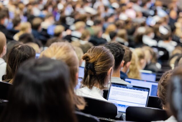 Studentinnen und Studenten sitzen während einer Vorlesung in einem Hörsaal der Westfälischen Wilhelms-Universität (WWU).