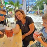 „Holzwickede karibisch“ 2023: Eine Familie sitzt an einer Biertisch-Garnitur und trinkt Cocktails.
