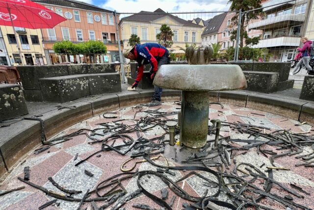 Im Eselsbrunnen am Markt in Unna entfernt ein Arbeiter die Silikonfugen zwischen den Steinen. Das Wasserspiel wird saniert.