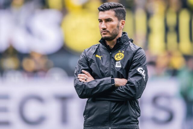 Nuri Sahin steht mit verschränkten Armen auf dem Platz.