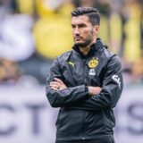Nuri Sahin steht mit verschränkten Armen auf dem Platz.