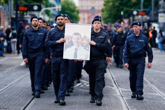In Gedenken an ihren tödlich verletzten Kollegen Rouven Laur ziehen Polizisten durch die Mannheimer Innenstadt.