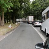 Zu sehen ist ein Rastplatz. Auf der linken Seite stehen geparkte Fahrzeuge.