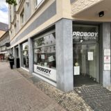 An der Ladenfront von Probody Sports Nutrition kleben viele weiße Zettel am Schaufenster.