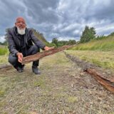Thomas Feldhaus aus Unna-Massen hockt auf der Finnenlaufbahn und zeigt morsches Holz.