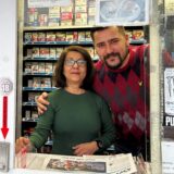 Eine Frau und ein Mann stehen in einem Kiosk. Das Foto ist von außen durch das Fenster gemacht. Rundherum sieht man Süßigkeiten und im Hintergrund Zigaretten.