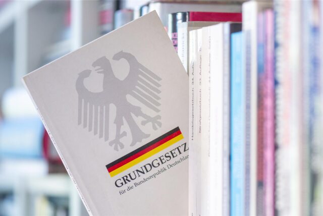 Das Grundgesetz der Bundesrepublik Deutschland steht in einem Regal.