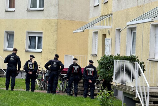 Polizisten stehen an einem Einsatzort, der möglichwerweise im Zusammenhang mit der Attacke in Wolmirstedt steht.