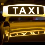 Ein Taxischild leuchtet auf dem Dach eines Taxis