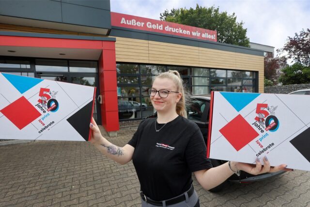 Kemna-Azubi Joyce Dahl präsentiert das Logo für das Firmenjubiläum.