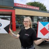 Kemna-Azubi Joyce Dahl präsentiert das Logo für das Firmenjubiläum.