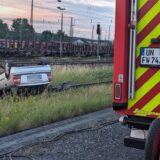 Ein silbernes Auto liegt am Bahnhof Schwerte im Gleisbett. Das Auto hat sich überschlagen und ist auf dem Dach gelandet.