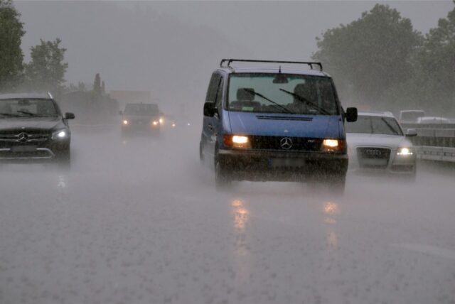 Auf einer Autobahn steht während eines starken Regengusses viel Wasser
