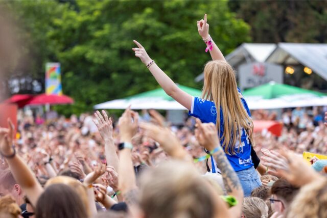 Feiernde Menschen beim Juicy Beats 2023. Die Festival-Bändchen werden in diesem Jahr noch wichtiger. Denn sie dienen zum Bezahlen.