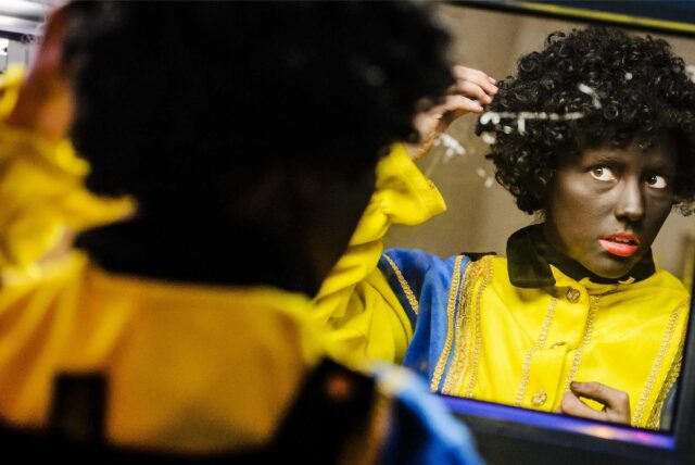Eine Frau kostümiert sich als Zwarte Piet.