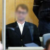 Ein Angeklagter sitzt hinter Panzerglas im Gerichtsaal des Oberlandesgerichts.