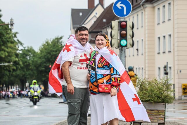 Zwei Georgier in ihre Flaggen gehüllt posieren auf der Straße.