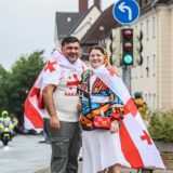 Zwei Georgier in ihre Flaggen gehüllt posieren auf der Straße.