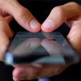 Ein Jugendlicher tippt auf einem Smartphone eine WhatsApp Nachricht.