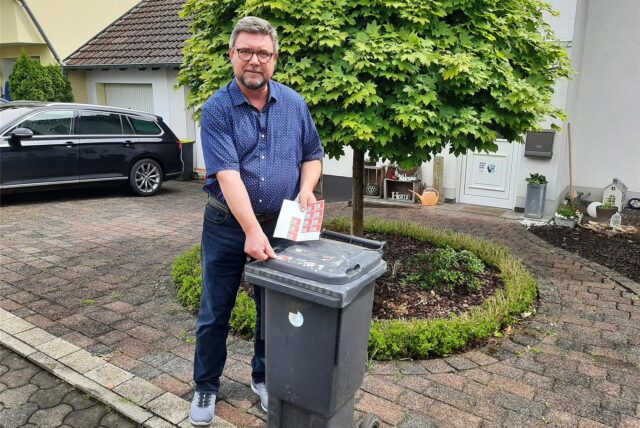 Tobias Habekost steht mit den bislang verfügbaren Wertmarken an seiner Restmülltonne.