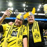 Zwei Fans prosten vor einem BVB-Spiel dem Fotografen zu.