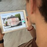 Ein Mann betrachtet das Bild eines Wohnhauses in einem Immobilienportal