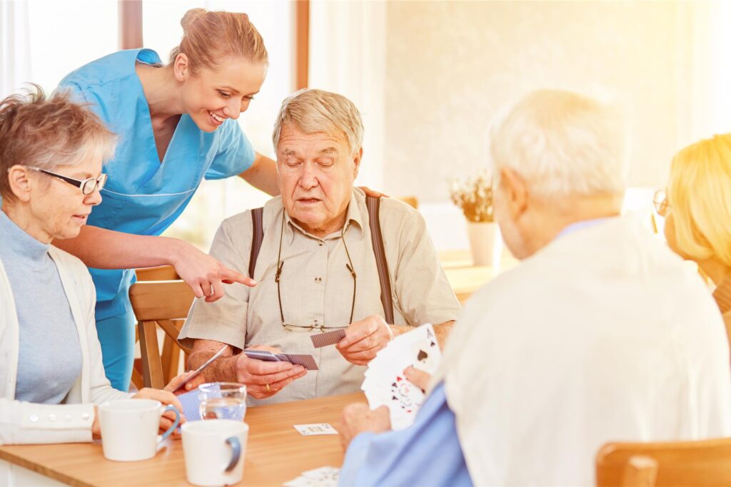 Pflegekraft im Gespräch mit Bewohnern Pflegekraft im Gespräch mit Bewohnern
