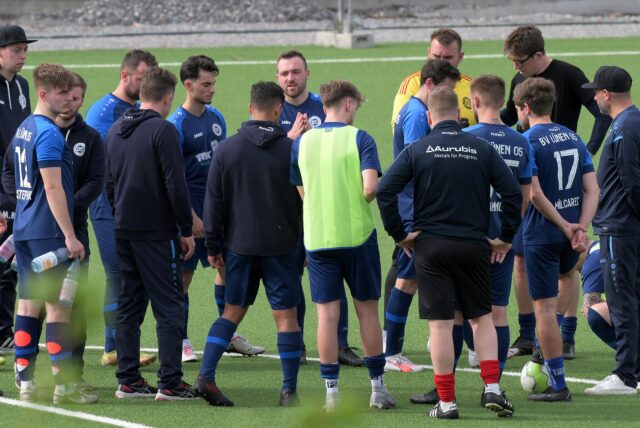 Die Spieler stehen versammelt im Kreis.