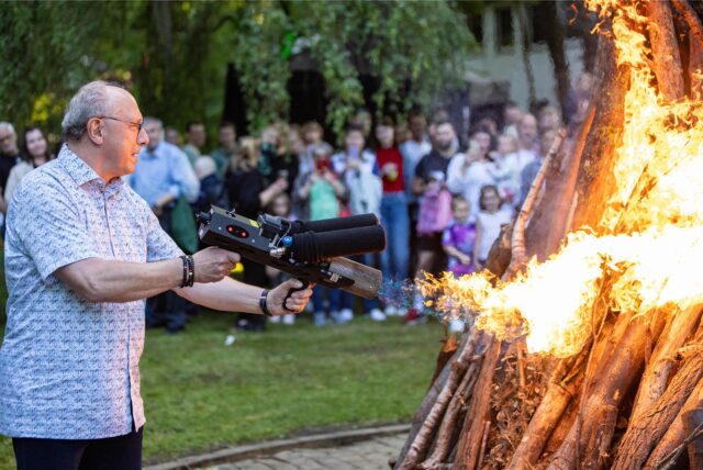 Ein Mann entzündet ein großes Feuer.