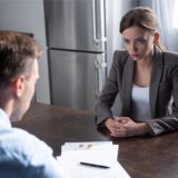 Paar sitzt am Tisch und diskutiert über Scheidung