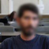 Der Angeklagte sitzt kurz vor Beginn der Verhandlung in einem Gerichtssaal.