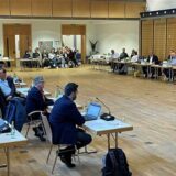 Politiker und Zuschauer in einer Ratssitzung