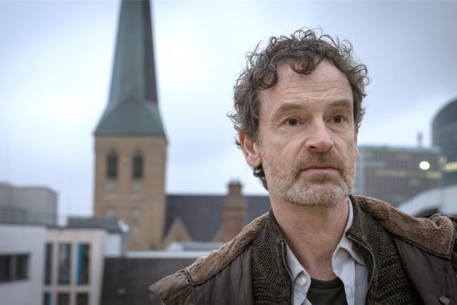 Tatort-Hauptkommissar Peter Faber (Jörg Hartmann) über den Dächern von Dortmund: Im Hintergrund ist die Petrikirche zu sehen.