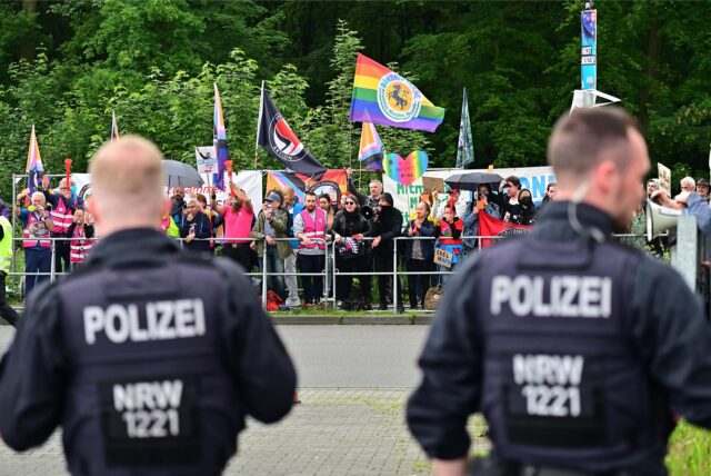 Polizeibeamte schirmen in Marl Politiker der AfD vor Demonstranten ab.