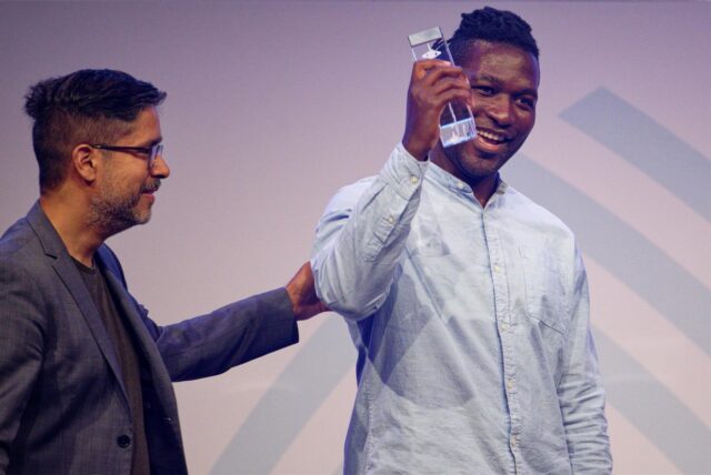 Steve Hiobi (r) und Laudator Hasnain Kazim stehen bei der Verleihung des Grimme Online Award 2023 mit dem Preis für „Dein Bruder Steve“ in der Kategorie „Information“ auf der Bühne.