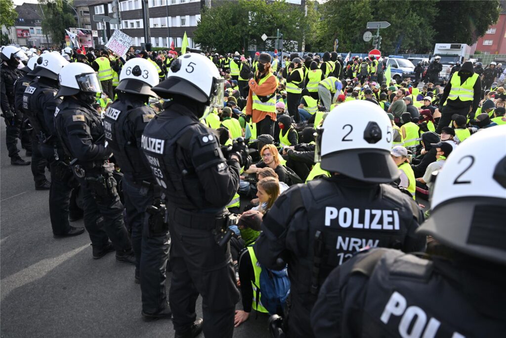 Demonstranten stehen und sitzen auf einer Zufahrtsstraße zum Gelände des AFD-Parteitags der Polizei gegenüber. Demonstranten stehen und sitzen auf einer Zufahrtsstraße zum Gelände des AFD-Parteitags der Polizei gegenüber.