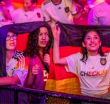 Das einsetzende Gewitter setzte den Public Viewings in Dortmund während des Spiels ein jähes Ende – hier versuchen sich Fans am Friedensplatz noch mit Flaggen vor dem Regen zu schützen.