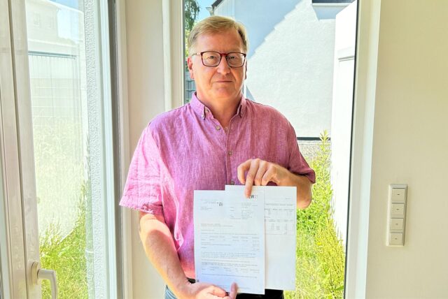 Ralph Froß hält die Rechnungen und Schreiben der DEW in die Kamera.